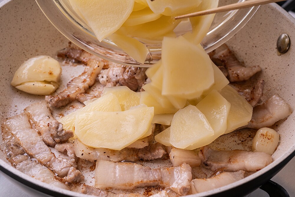フライパンに2のにんにくと豚肉を入れて中火で炒める。豚肉に火が通ったら1のじゃがいもを加え、混ぜながら炒める。