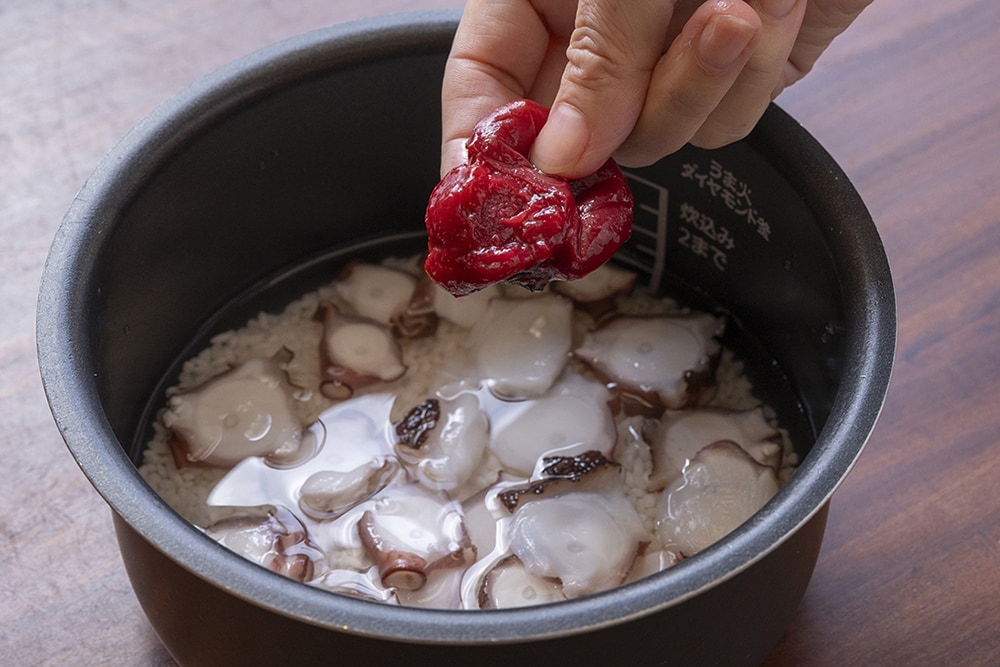 炊飯器に洗った米とAを入れてひと混ぜし、１のタコを入れ、手で潰した梅干しを種ごとのせて普通に炊く。※梅干の種も一緒に炊飯することで、種からもいいだしが出ます。
