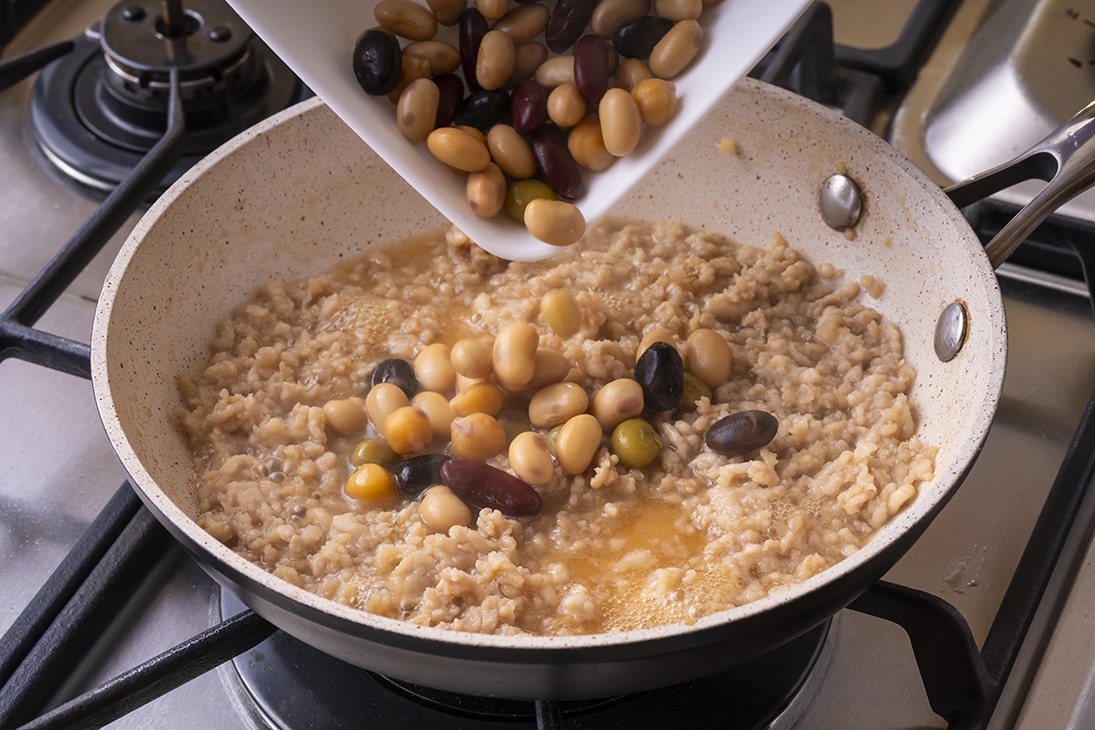 鶏肉に火が通ったら、蒸し豆を入れる。