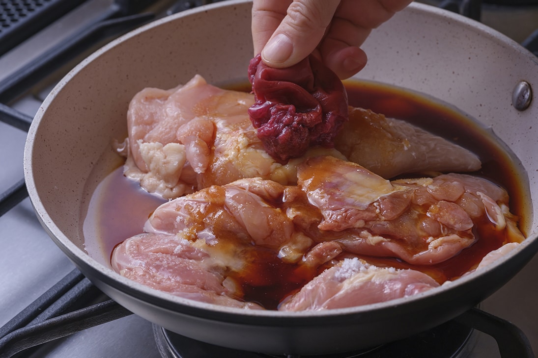鶏肉（もも肉とむね肉）をフライパンに入れ、Aを加えて蓋をして中火にかける。
